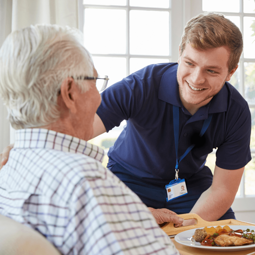 Male nurse helping senior at mealtime